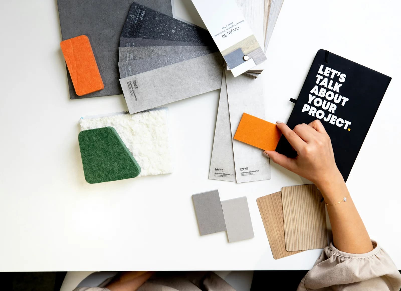 Flat lay of fabric swatches and plans representing an interior design product library.